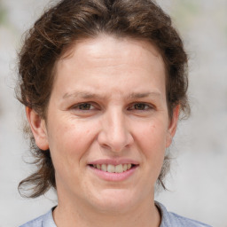 Joyful white adult female with medium  brown hair and grey eyes