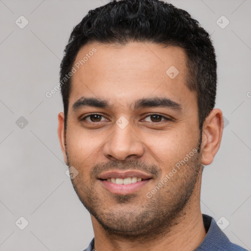Joyful white young-adult male with short  black hair and brown eyes