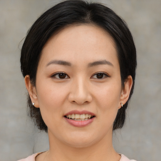 Joyful asian young-adult female with medium  black hair and brown eyes