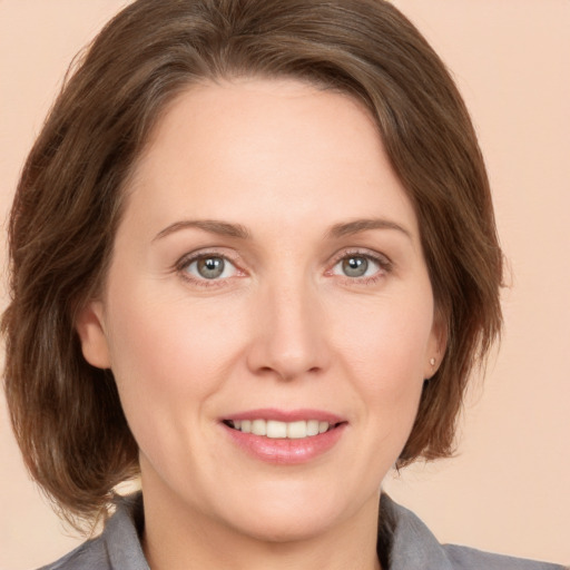 Joyful white adult female with medium  brown hair and grey eyes