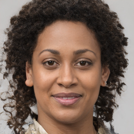 Joyful black adult female with medium  brown hair and brown eyes