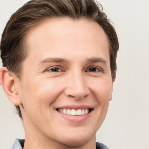 Joyful white young-adult male with short  brown hair and grey eyes