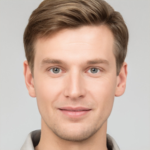 Joyful white young-adult male with short  brown hair and grey eyes