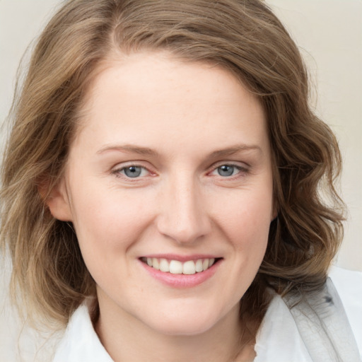 Joyful white young-adult female with medium  brown hair and blue eyes