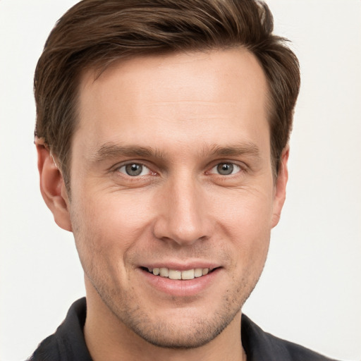 Joyful white young-adult male with short  brown hair and grey eyes