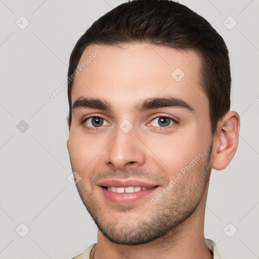 Joyful white young-adult male with short  brown hair and brown eyes