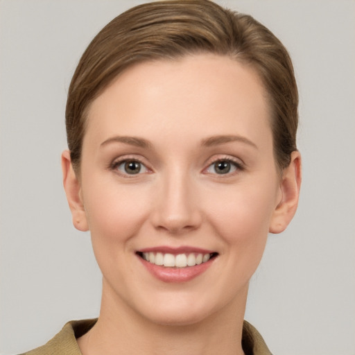 Joyful white young-adult female with short  brown hair and grey eyes