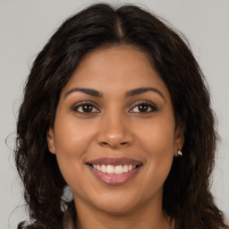 Joyful latino young-adult female with long  brown hair and brown eyes