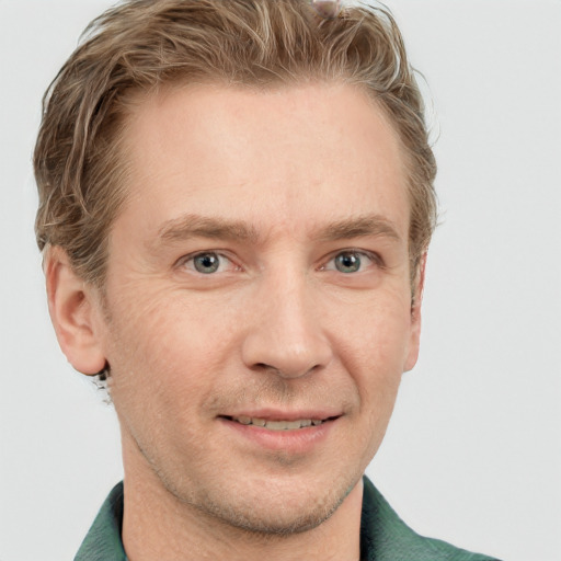 Joyful white adult male with short  brown hair and blue eyes