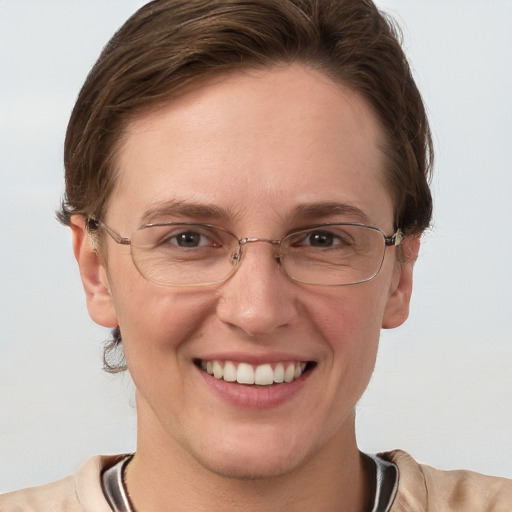 Joyful white adult female with short  brown hair and blue eyes