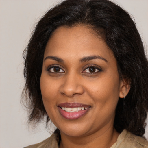 Joyful black young-adult female with medium  brown hair and brown eyes