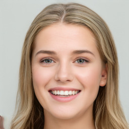 Joyful white young-adult female with long  brown hair and blue eyes