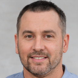 Joyful white adult male with short  brown hair and brown eyes