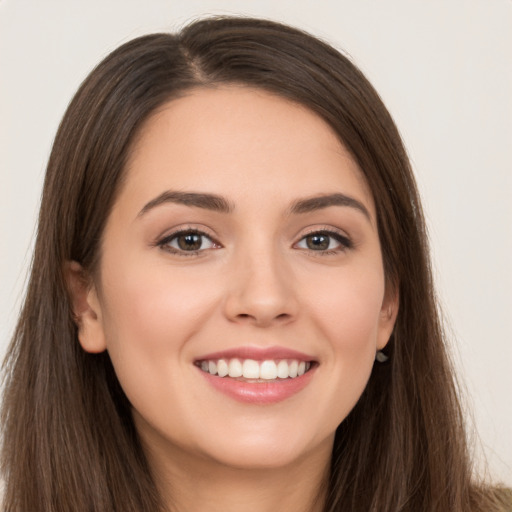 Joyful white young-adult female with long  brown hair and brown eyes