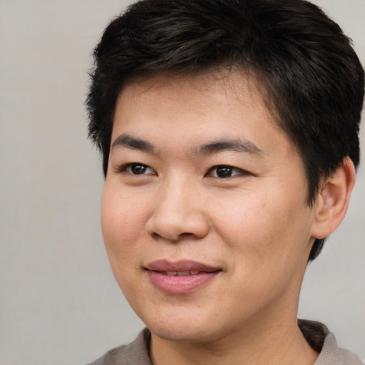 Joyful asian young-adult male with short  brown hair and brown eyes