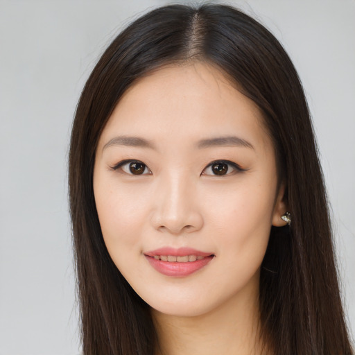 Joyful asian young-adult female with long  brown hair and brown eyes
