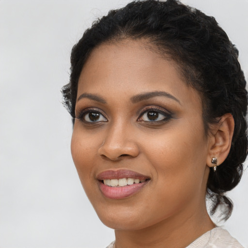 Joyful black young-adult female with long  brown hair and brown eyes