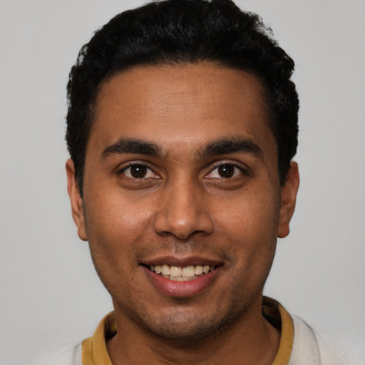 Joyful latino young-adult male with short  black hair and brown eyes