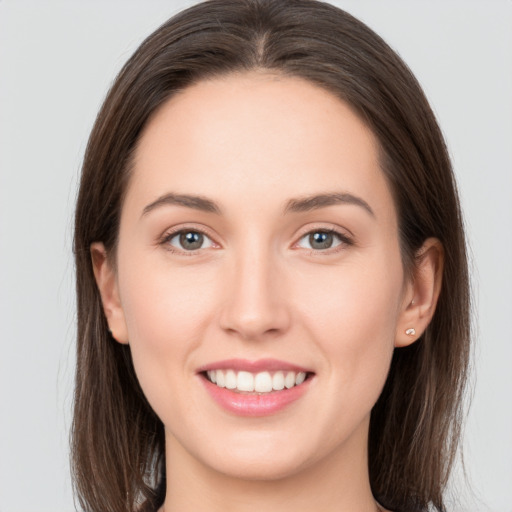 Joyful white young-adult female with long  brown hair and grey eyes