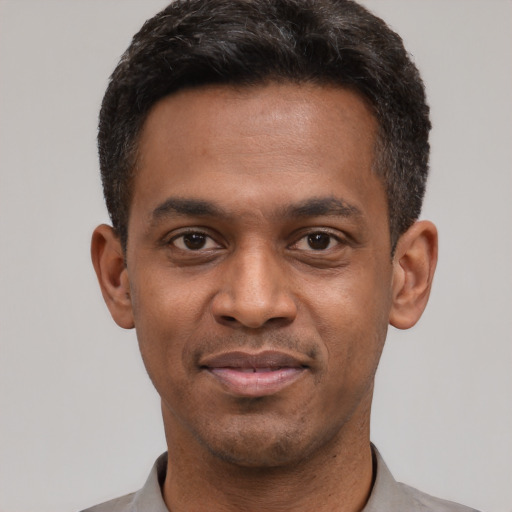 Joyful latino young-adult male with short  black hair and brown eyes