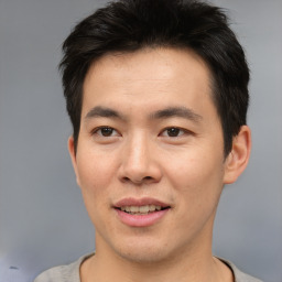 Joyful asian young-adult male with short  brown hair and brown eyes