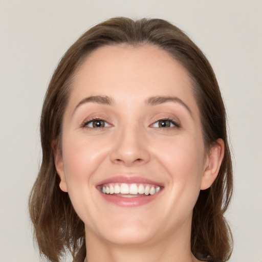 Joyful white young-adult female with medium  brown hair and grey eyes