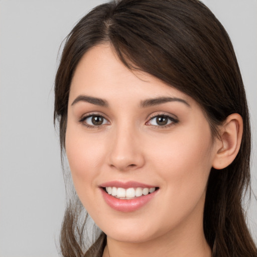 Joyful white young-adult female with long  brown hair and brown eyes