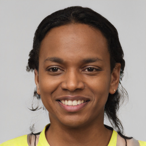 Joyful black young-adult female with short  black hair and brown eyes