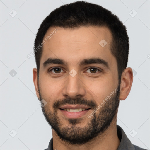 Joyful white young-adult male with short  black hair and brown eyes