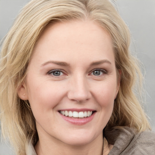 Joyful white young-adult female with medium  brown hair and blue eyes