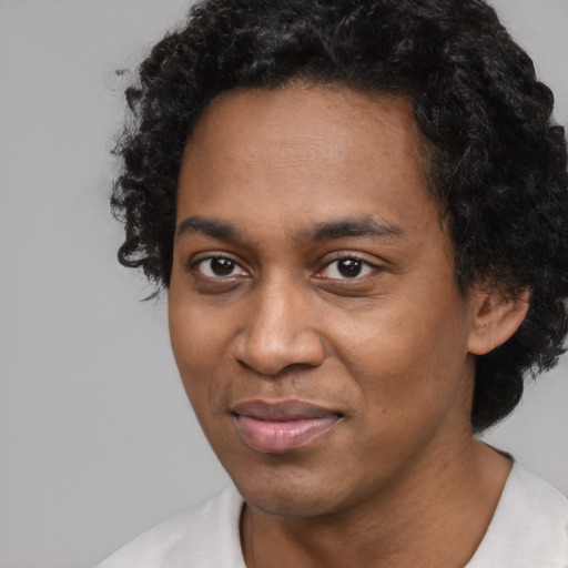 Joyful black adult male with short  black hair and brown eyes