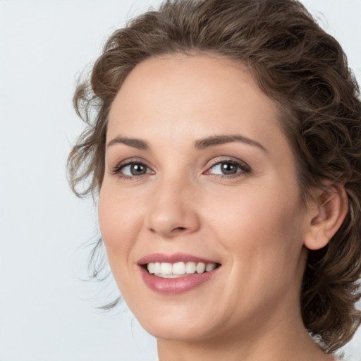 Joyful white young-adult female with medium  brown hair and green eyes