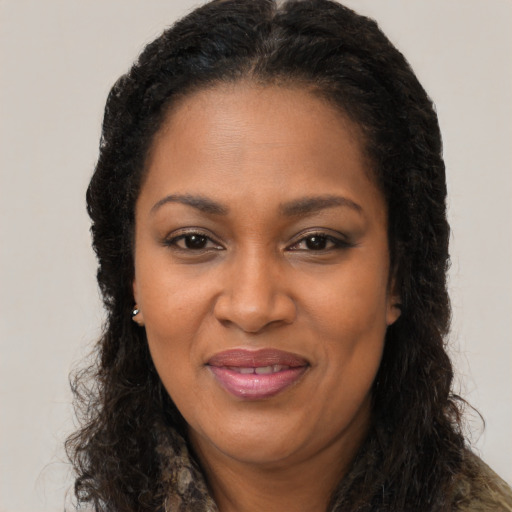 Joyful black adult female with long  brown hair and brown eyes