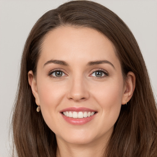 Joyful white young-adult female with long  brown hair and grey eyes