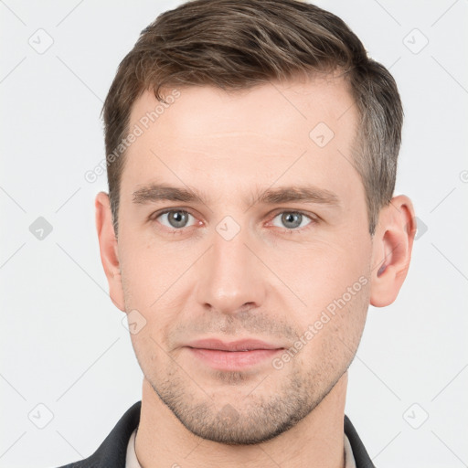 Joyful white young-adult male with short  brown hair and grey eyes