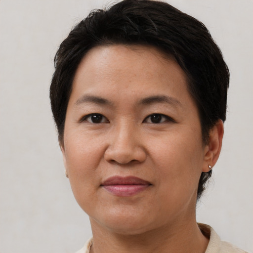 Joyful asian adult female with short  brown hair and brown eyes