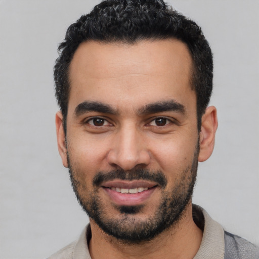 Joyful latino young-adult male with short  black hair and brown eyes
