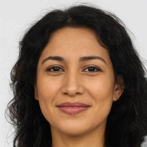 Joyful latino adult female with long  brown hair and brown eyes