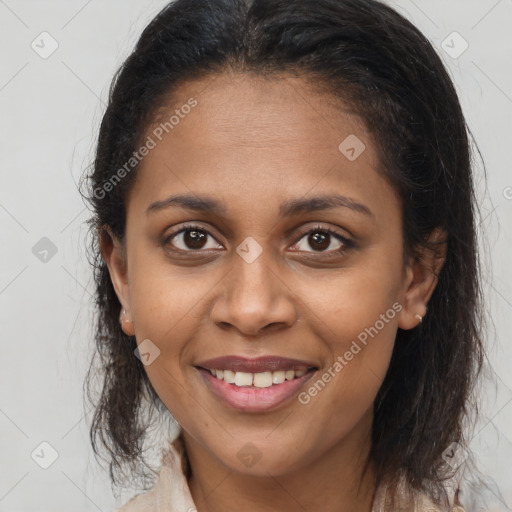 Joyful black young-adult female with long  brown hair and brown eyes