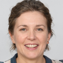 Joyful white adult female with medium  brown hair and grey eyes