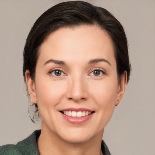 Joyful white young-adult female with medium  brown hair and grey eyes