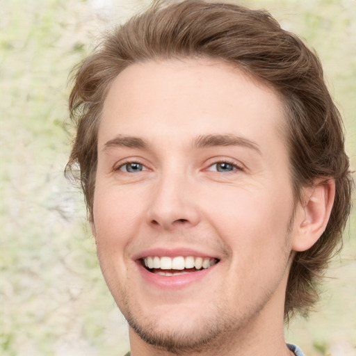 Joyful white young-adult male with short  brown hair and green eyes