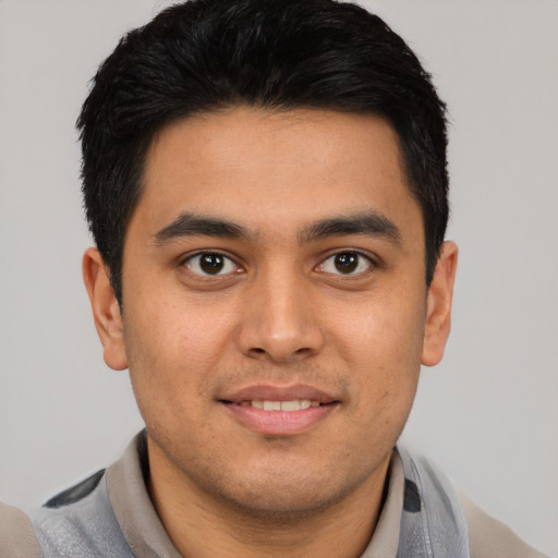 Joyful latino young-adult male with short  black hair and brown eyes