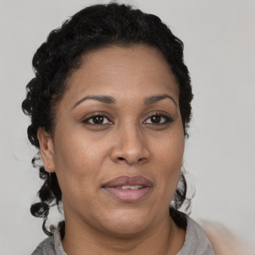Joyful latino adult female with short  black hair and brown eyes