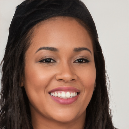 Joyful latino young-adult female with long  brown hair and brown eyes