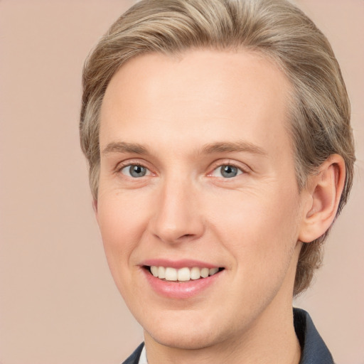 Joyful white young-adult male with medium  brown hair and grey eyes