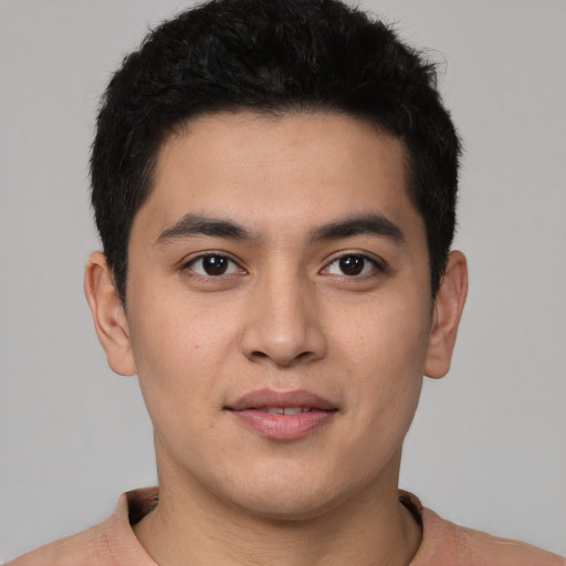 Joyful latino young-adult male with short  brown hair and brown eyes