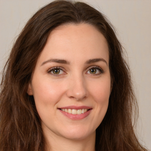 Joyful white young-adult female with long  brown hair and brown eyes