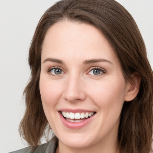 Joyful white young-adult female with long  brown hair and green eyes