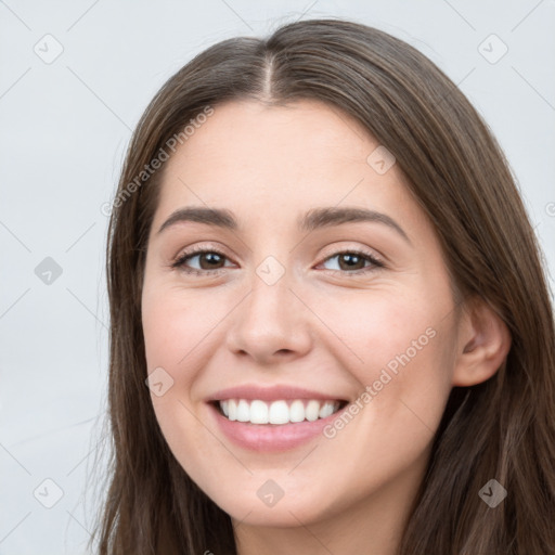 Joyful white young-adult female with long  brown hair and grey eyes